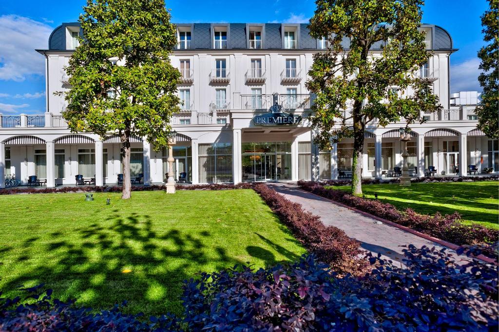 un grand bâtiment blanc avec des arbres devant lui dans l'établissement Hotel Premiere Abano, à Abano Terme