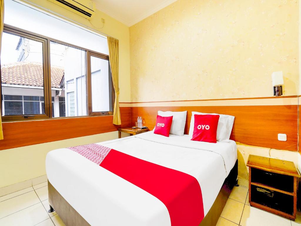 a hotel room with two beds with red pillows at OYO Collection O 91297 Hotel Sakura in Bandung