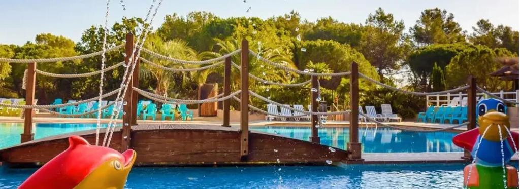 a water park with a large swimming pool with a water slide at Chalets met buitenkeuken op Camping Leï Suves - JoyCasa in Roquebrune-sur-Argens