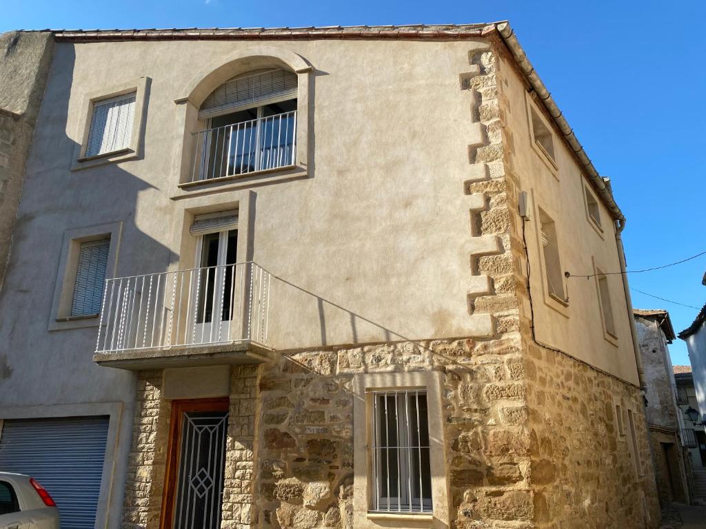 an old stone building with a balcony on it at Cal cap xic in Castellfullit de Riubregós