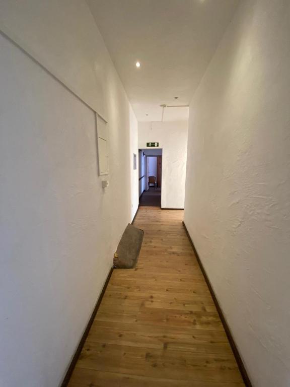 - un couloir avec un mur blanc et du parquet dans l'établissement Budget Hotel Mannheim, à Mannheim