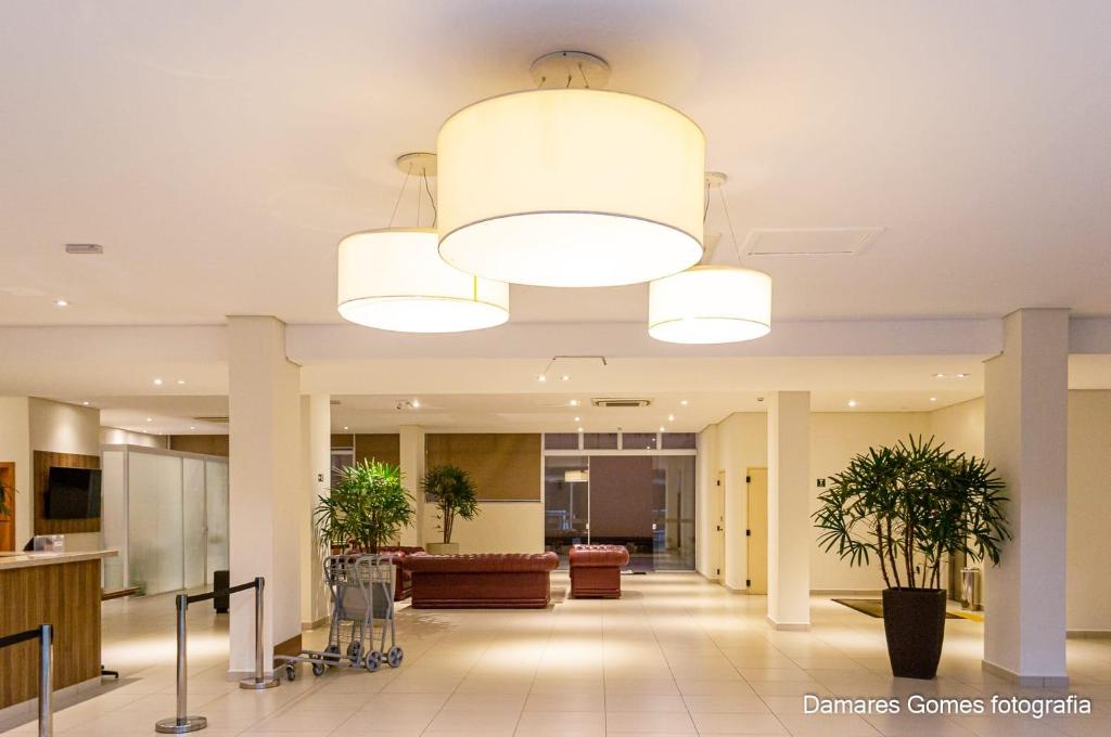 un vestíbulo de un hospital con un techo grande en Hotel Malibu Inn en Campinas