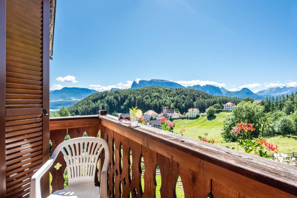 a balcony with a chair and a view of mountains at Sallrain Hof Apartment 2 in Collalbo