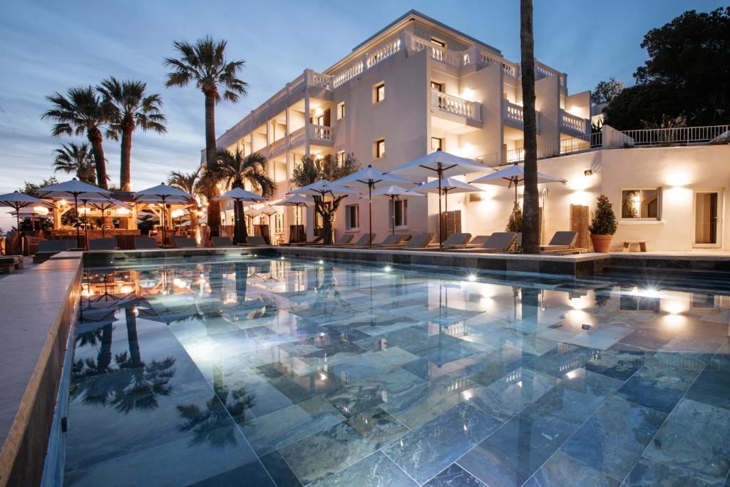 um hotel com piscina em frente a um edifício em Le Mirage em Bormes-les-Mimosas