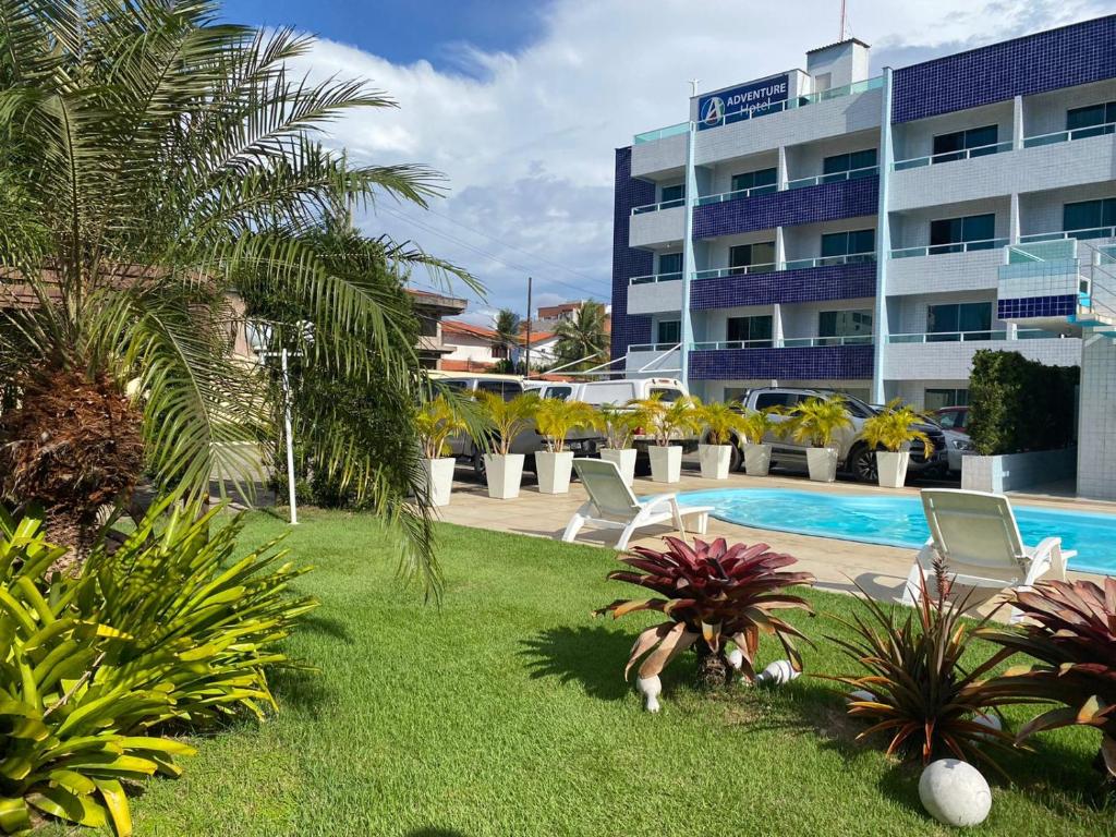 a resort with a pool and chairs and a building at Hotel Adventure São Luís in São Luís