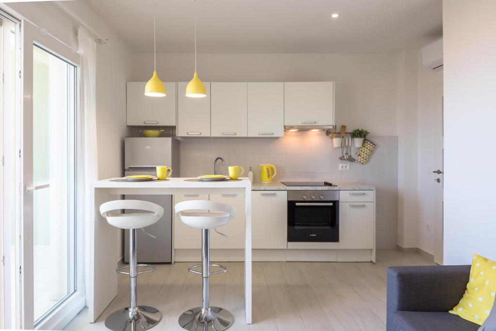 a kitchen with a counter and stools in a room at Ksenija Apartments in Tučepi