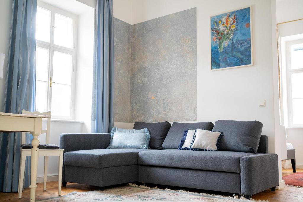 a couch in a living room with blue curtains at Ferienwohnung Sandwirtin in Schwanberg