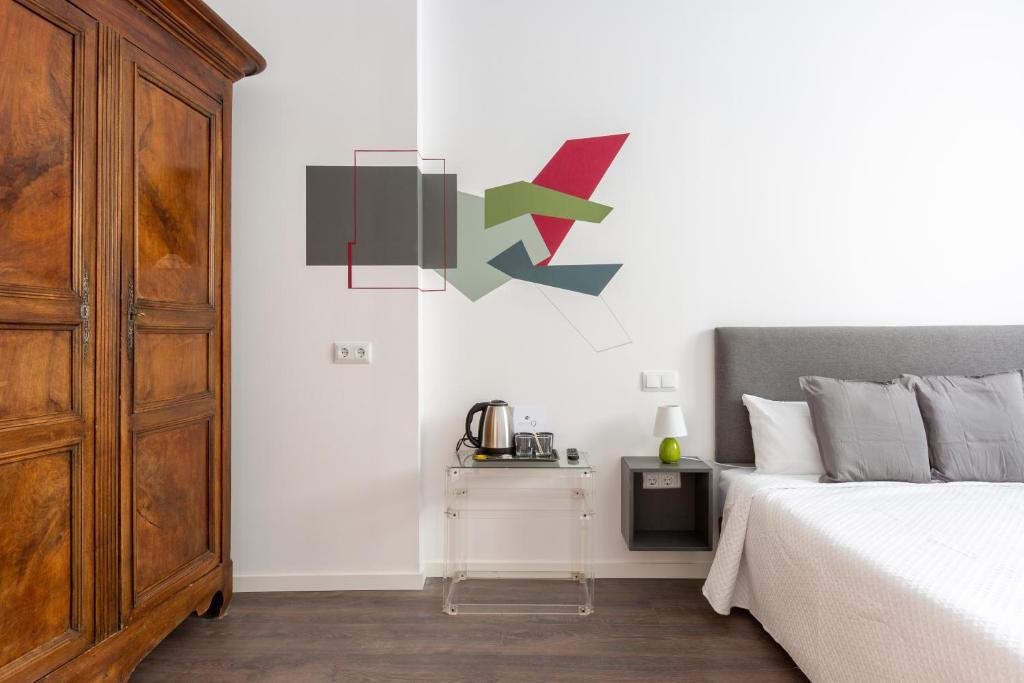 um quarto com uma cama e uma cómoda com um relógio na parede em Ronda9 central suites em Madri