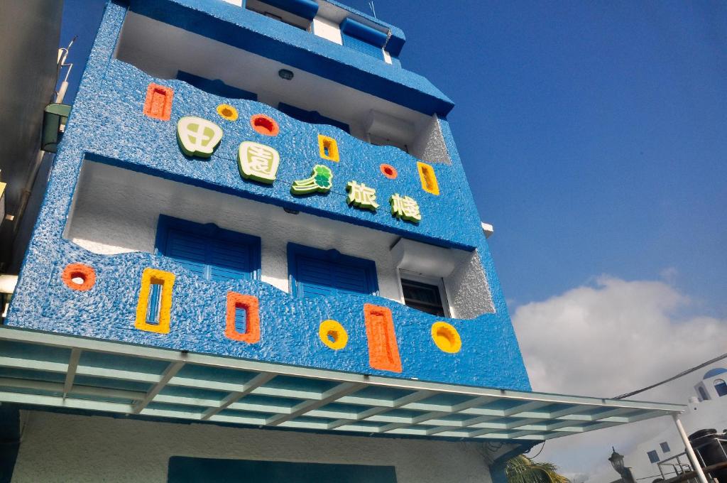 un edificio blu con orologi su un lato di Country Kos Hostel a Kenting