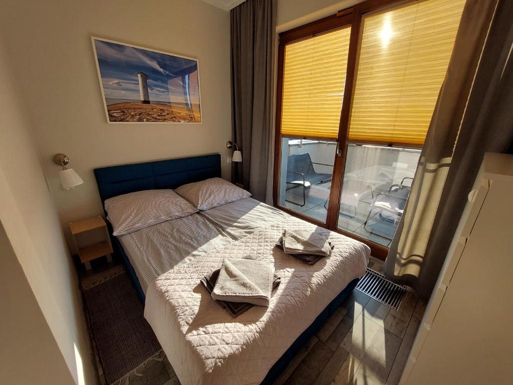 una camera da letto con un letto e due asciugamani di Apartament Słoneczna z parkingiem a Świnoujście