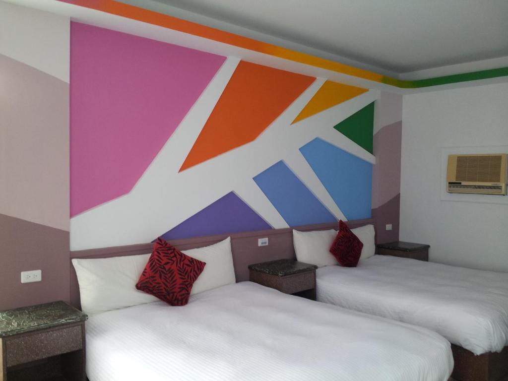 two beds in a room with a colorful wall at Country Kos Hostel in Kenting