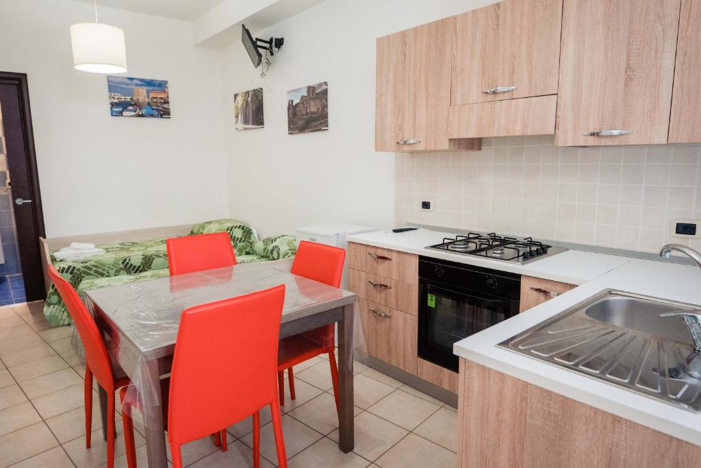 uma cozinha com uma mesa e cadeiras e um lavatório em B&B Dell'Infopoint-La Via Silente em Castelnuovo Cilento