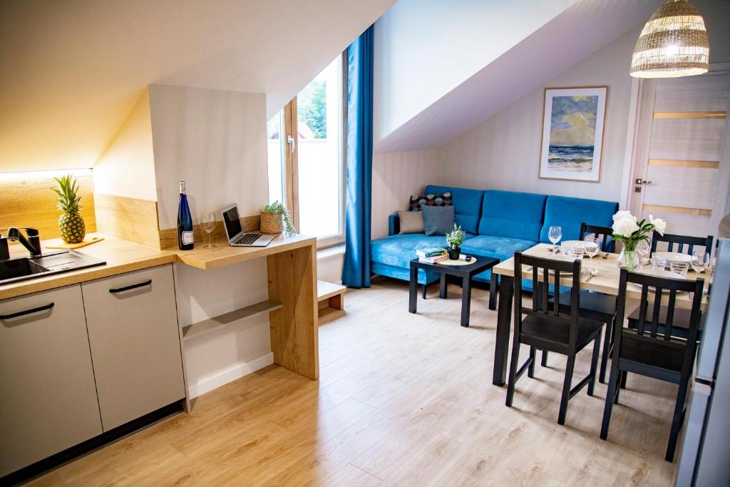 eine Küche und ein Wohnzimmer mit einem Tisch und einem Sofa in der Unterkunft Apartamenty z tarasami - Moja Gdynia in Gdynia