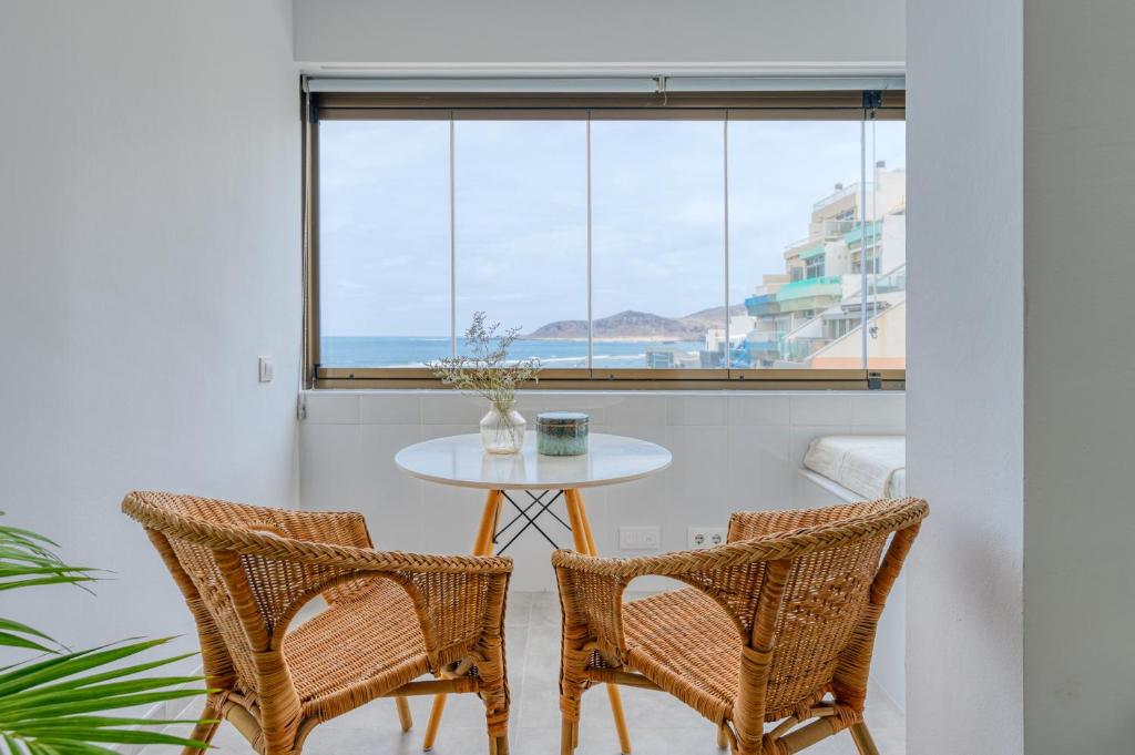 uma mesa e duas cadeiras num quarto com uma janela em Stylish Sea View Accommodation Las Canteras em Las Palmas de Gran Canaria