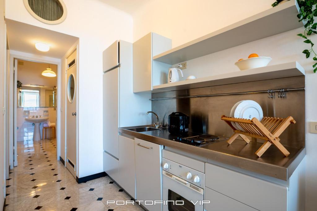 a kitchen with white cabinets and a counter top at San Giorgio by PortofinoVip in Portofino