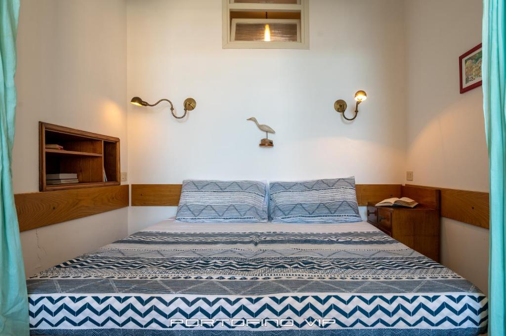 a bedroom with a bed with blue and white sheets at Casa San Giorgio by PortofinoVip in Portofino