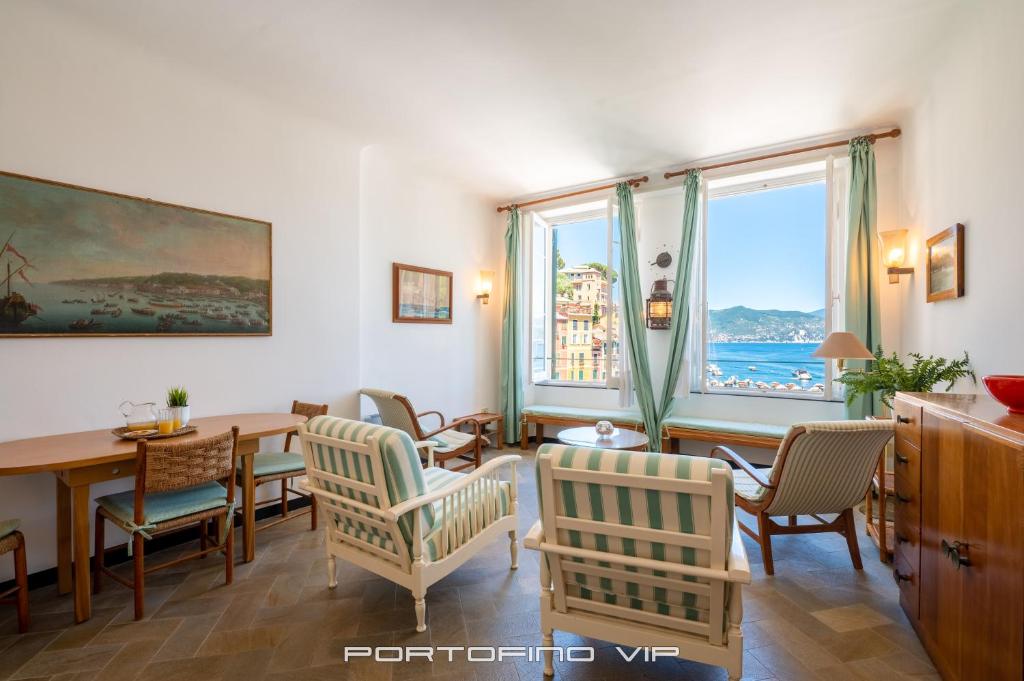 a living room with a table and chairs and a large window at San Giorgio by PortofinoVip in Portofino