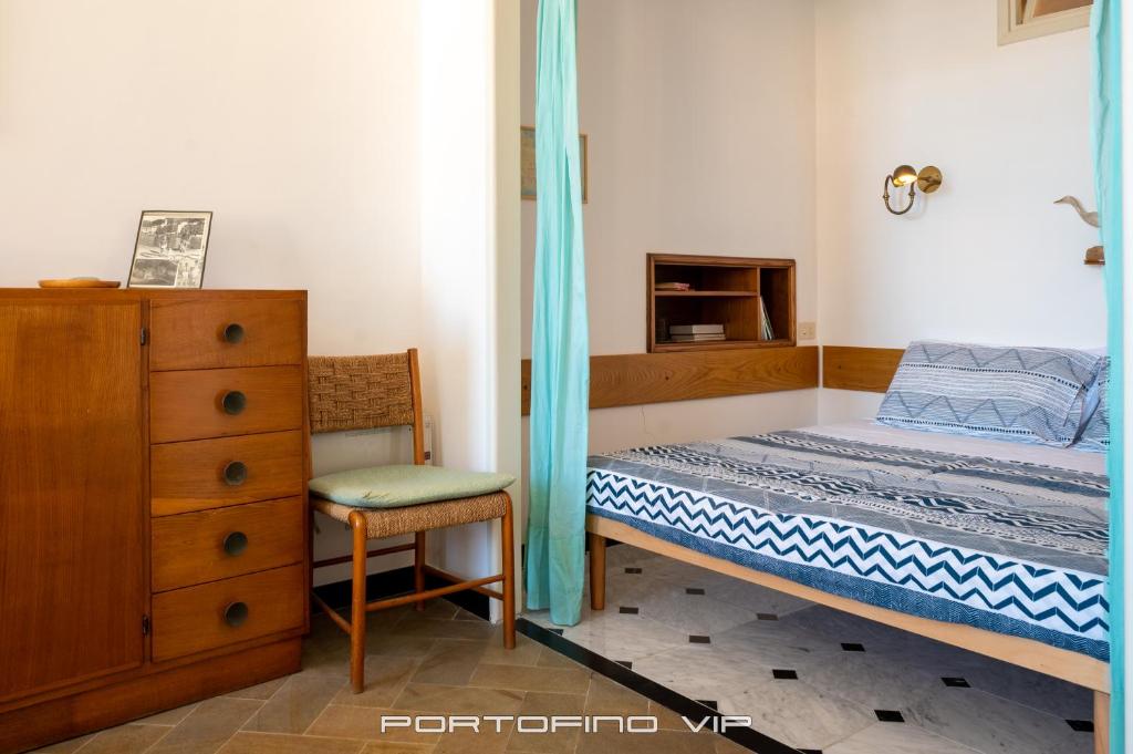 a bedroom with a bed and a chair and a dresser at San Giorgio by PortofinoVip in Portofino