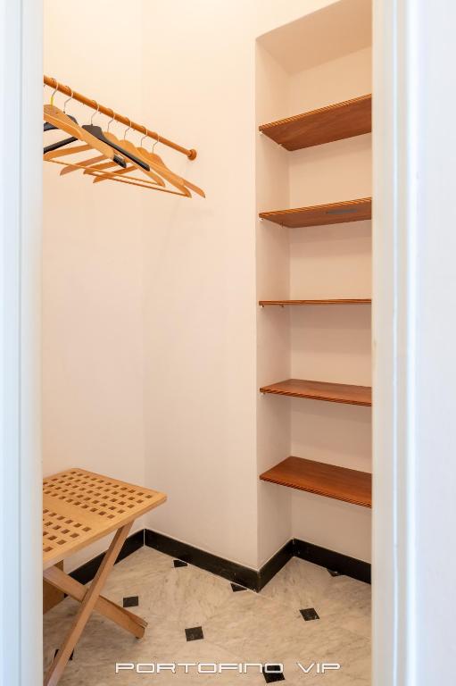 a walk in closet with wooden shelves at San Giorgio by PortofinoVip in Portofino