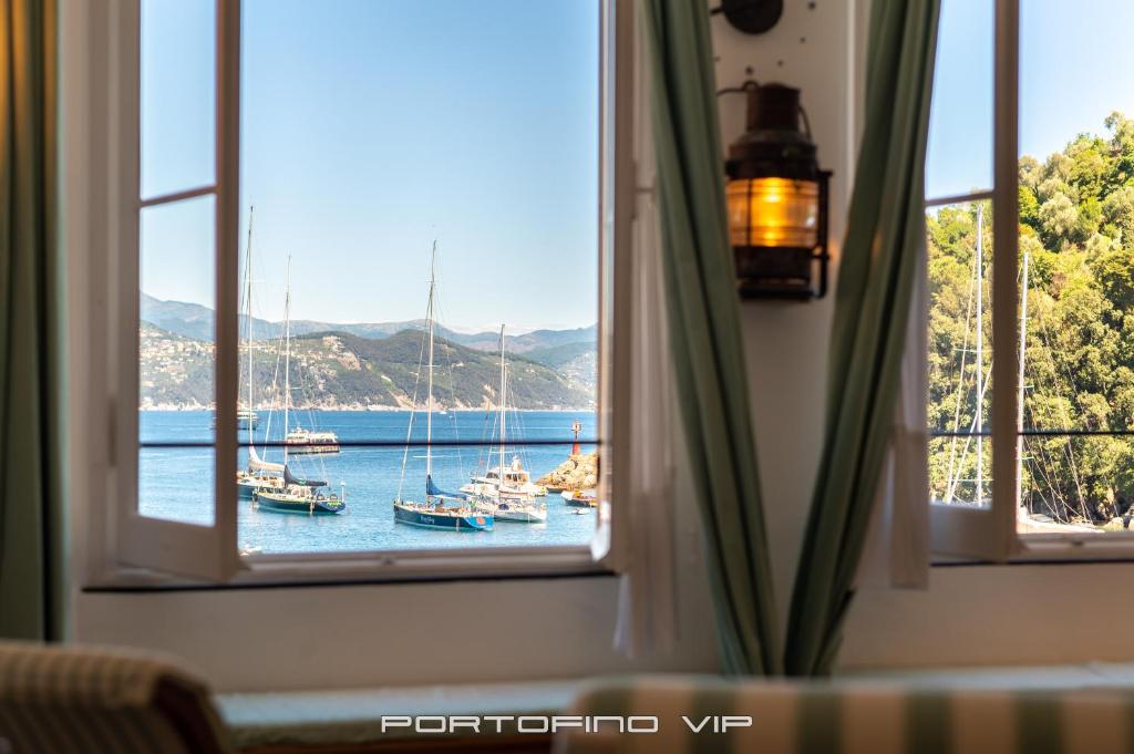 a window view of a harbor with boats in the water at San Giorgio by PortofinoVip in Portofino