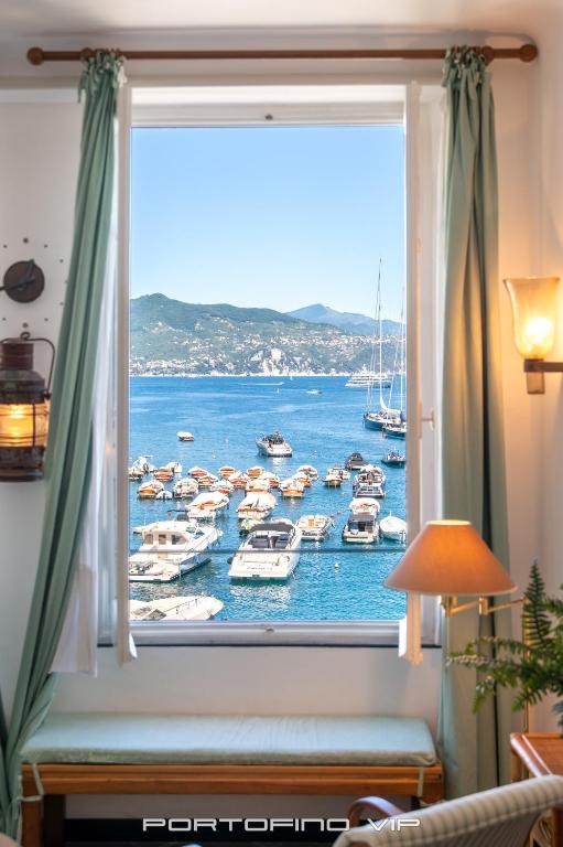 a window with a view of boats in the water at San Giorgio by PortofinoVip in Portofino
