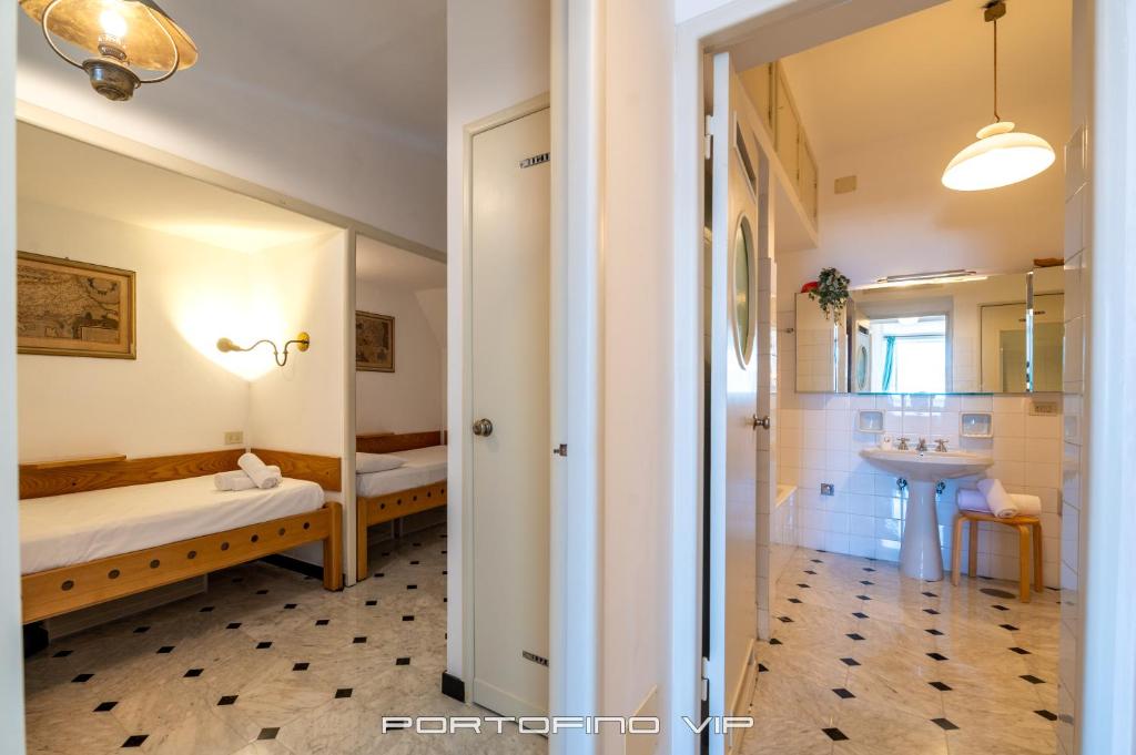 a bedroom with a bed and a sink and a mirror at San Giorgio by PortofinoVip in Portofino