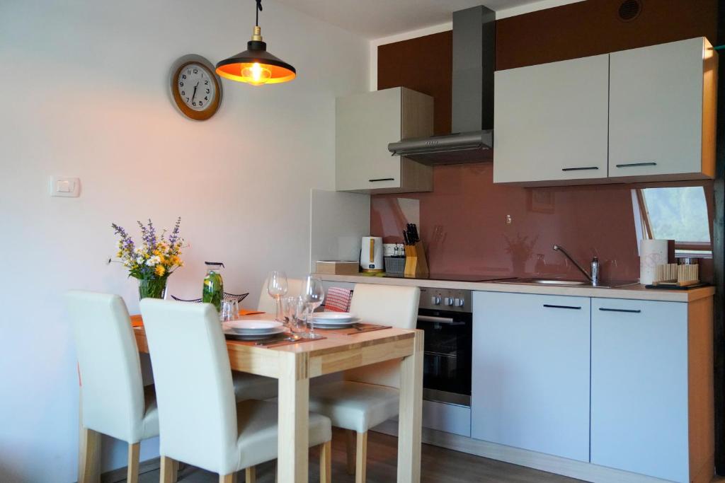 cocina con mesa de madera y armarios blancos en Apartment Alpea, en Bovec