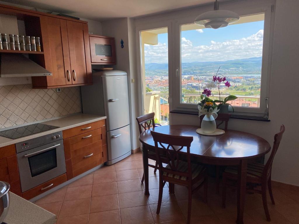 uma cozinha com uma mesa com um vaso de flores em Lovely apartment with fabulous view em Koper