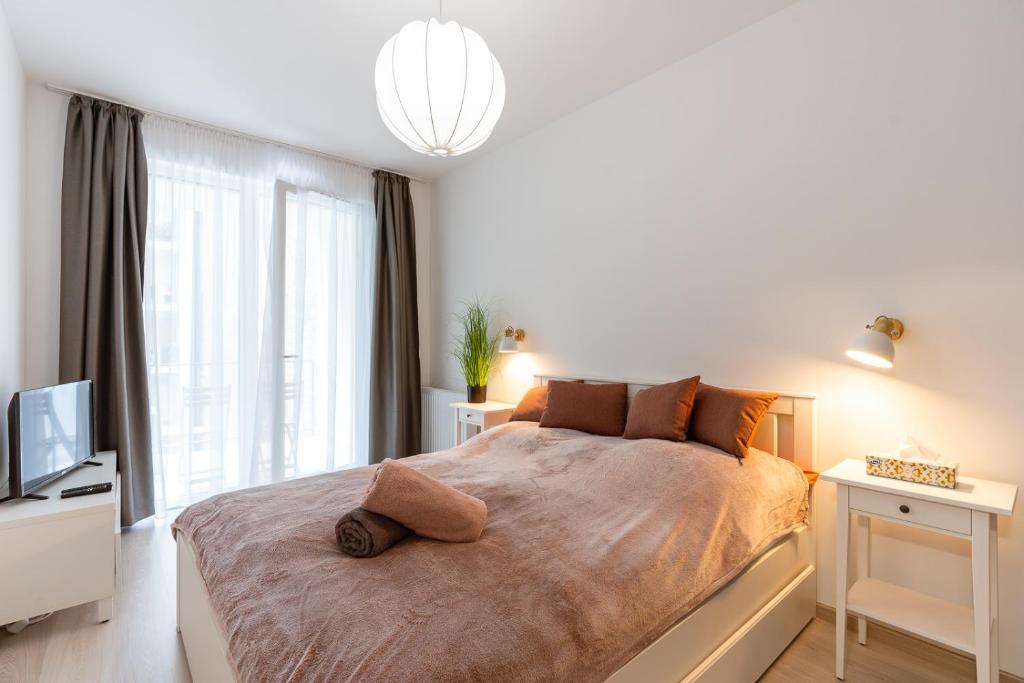 a bedroom with a large bed and a television at Modern & Newly built apartment with private garage in Budapest