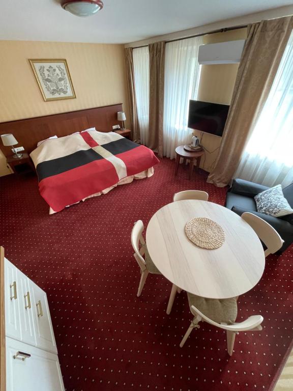 a hotel room with a table and a bed at Morena Liux Apartment in Klaipėda