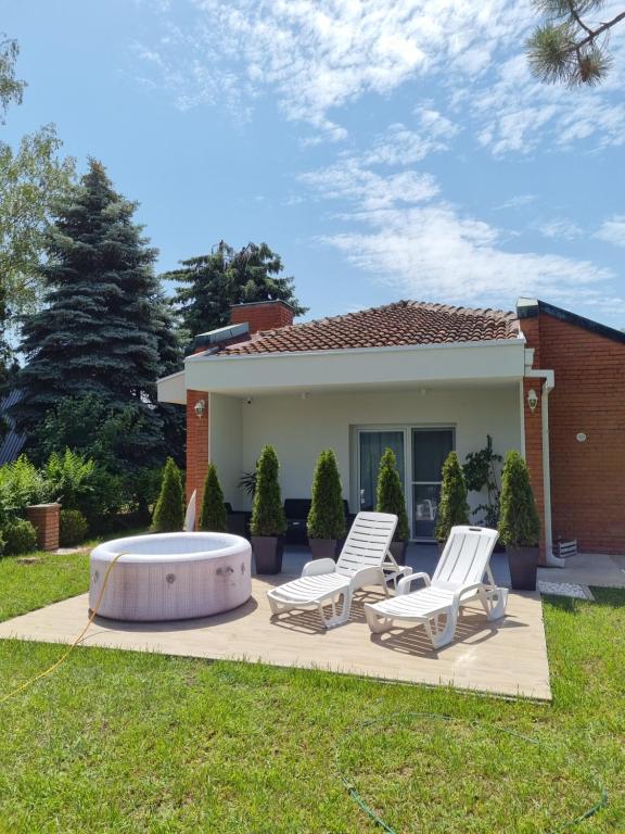 une arrière-cour avec deux chaises longues et un bain à remous dans l'établissement Apartman277 Palić, à Palić