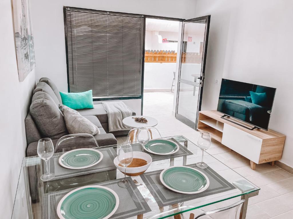 un soggiorno con tavolo e piastre verdi di Dahlia Apartment DunaSol a Corralejo