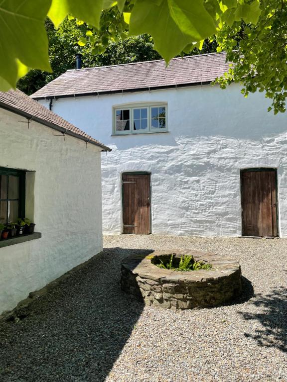卡迪根的住宿－The Cottage at Noyadd Trefawr - Grade II*，白色的建筑,设有两扇门和一扇窗户