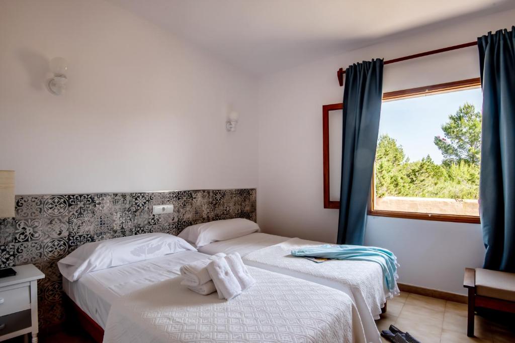 two beds in a room with a window at Aguamar - Emar Hotels in Playa Migjorn