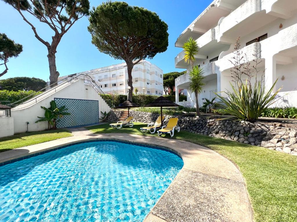 a swimming pool in the yard of a house with a building at Sea Gardens - Alvaflor - Vilamoura in Vilamoura