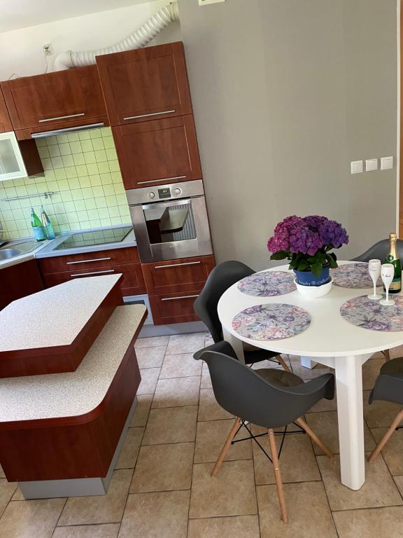 een keuken met een tafel en stoelen met bloemen erop bij Bellis Apartment in Szczecin