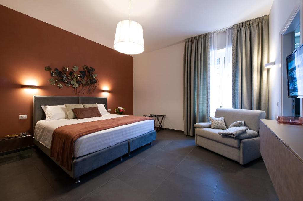 a hotel room with a bed and a chair at Clover - 13 Piazza Pio XI in Rome