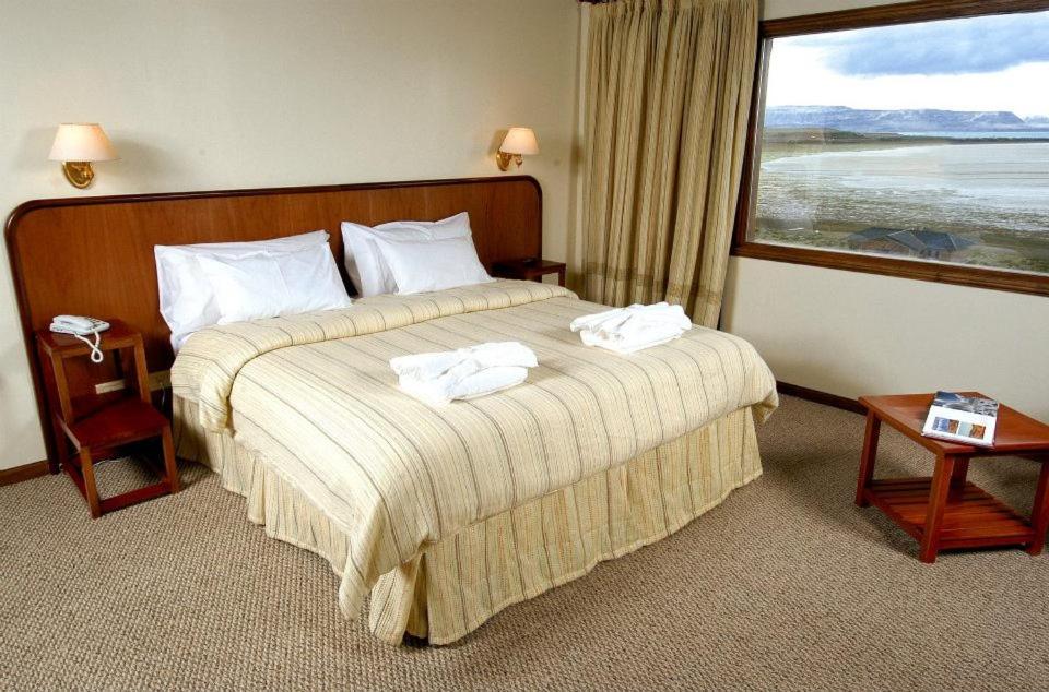 a hotel room with a bed with towels on it at Koi Aiken in El Calafate