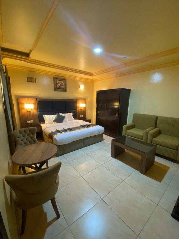 a hotel room with a bed and a table and chairs at فندق ديوان اليمامة in Taif