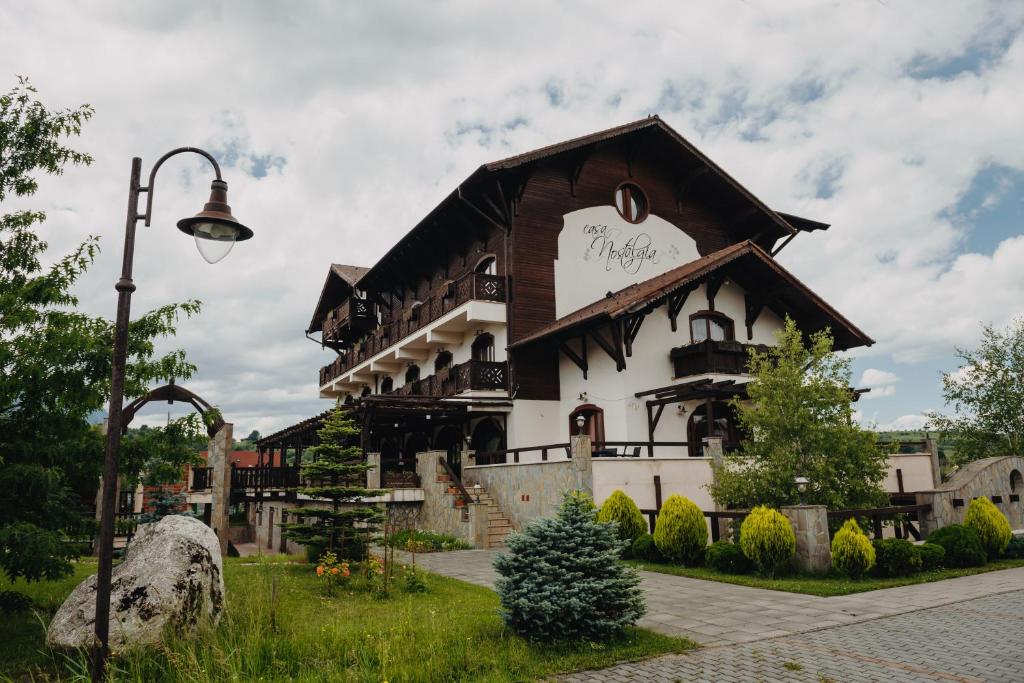 ein großes Gebäude mit einem Schild drauf in der Unterkunft Pensiunea Casa Nostalgia in Bran