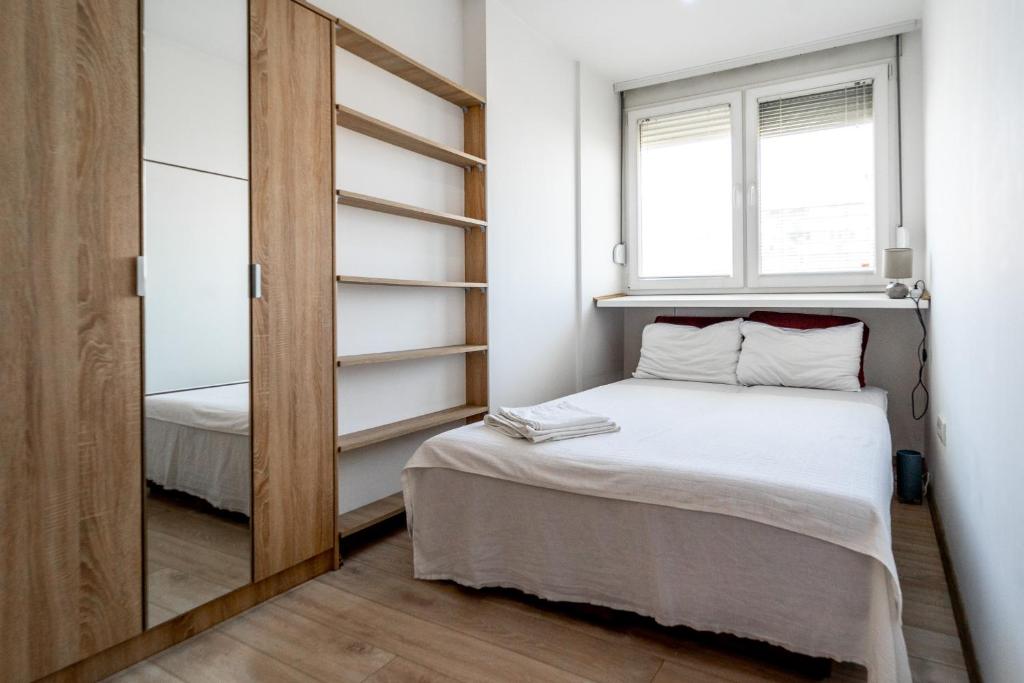a small bedroom with a bed and a window at Apartman Šumice in Vračar (historical)