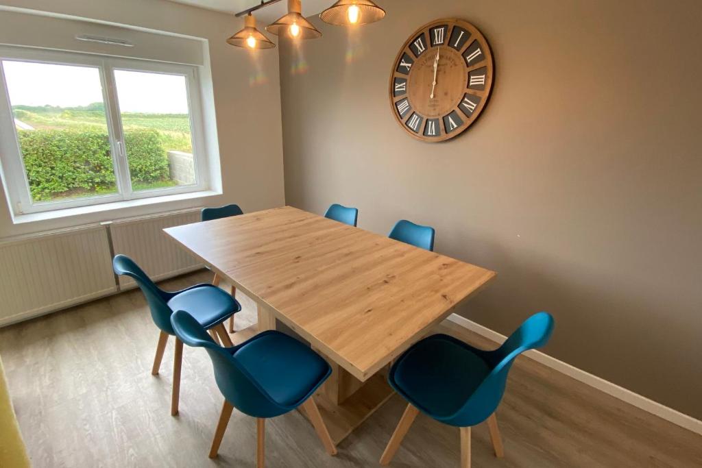 a dining room with a wooden table and blue chairs at Saint-Pol family house garden fully equipped 12 people in Saint-Pol-de-Léon