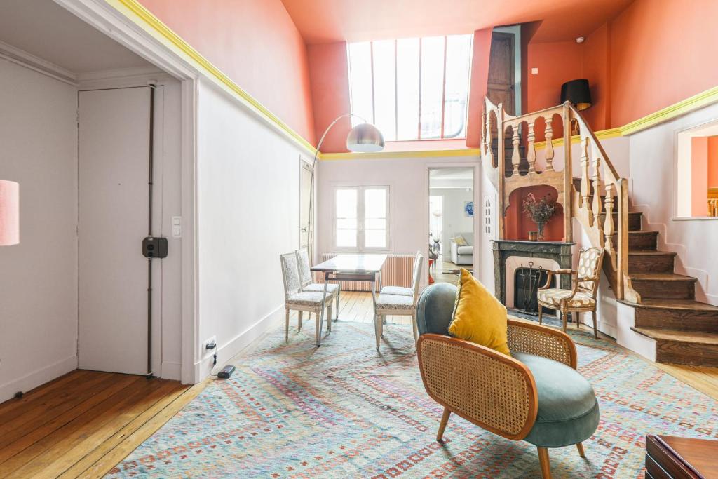 - un salon avec des murs orange, une table et des chaises dans l'établissement Artists' studio on the roofs of Montmartre - Welkeys, à Paris