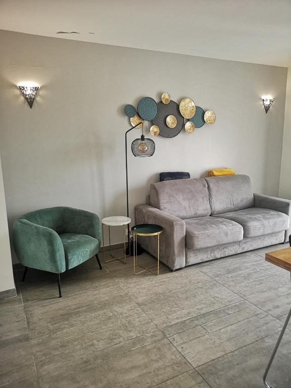 un salon avec un canapé et une chaise dans l'établissement Appartement contemporain le Vendome à 90m de la plage, au Grau-du-Roi