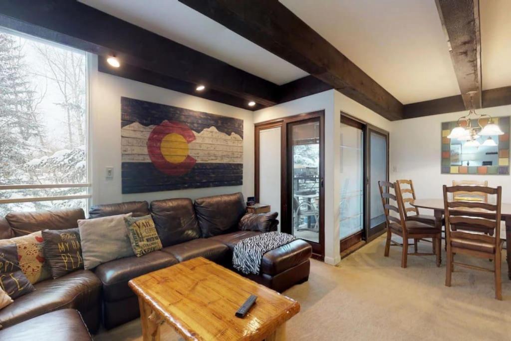 ein Wohnzimmer mit einem Ledersofa und einem Tisch in der Unterkunft Perfect 3BD Lionshead Condo in Vail