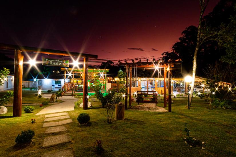 um parque à noite com luzes em frente a um edifício em Chale Luiz em Santo Antônio do Pinhal