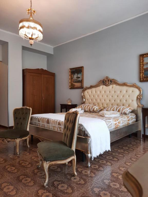 アグローポリにあるVilla Ada B&Bのベッドルーム1室(ベッド1台、椅子、シャンデリア付)