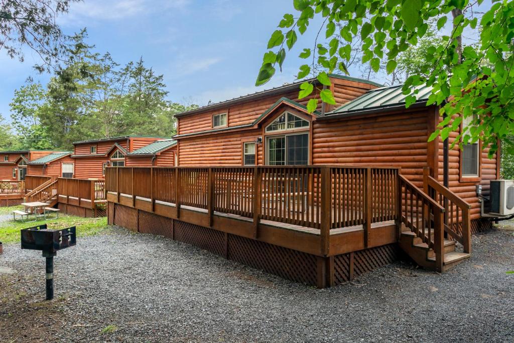 a large wooden cabin with a large deck at Drummer Boy Camping Resort in Gettysburg