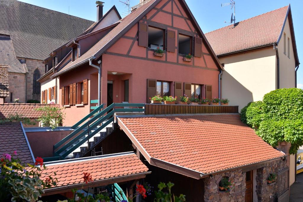 una casa con techos y plantas de baldosas rojas en S'Harzala Vert bis en Bergheim