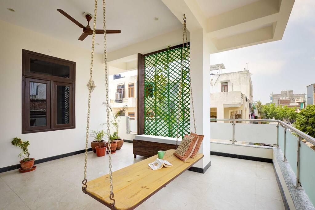 a porch with a swinging bench on a balcony at Tejdeep - A boutique 3BHK homestay in Jaipur